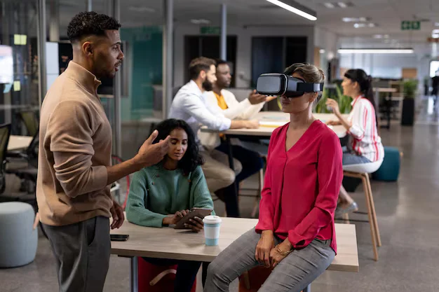 hispanic businesswoman discussing with caucasian businesswoman wearing vr simulator meeting 13339 333196